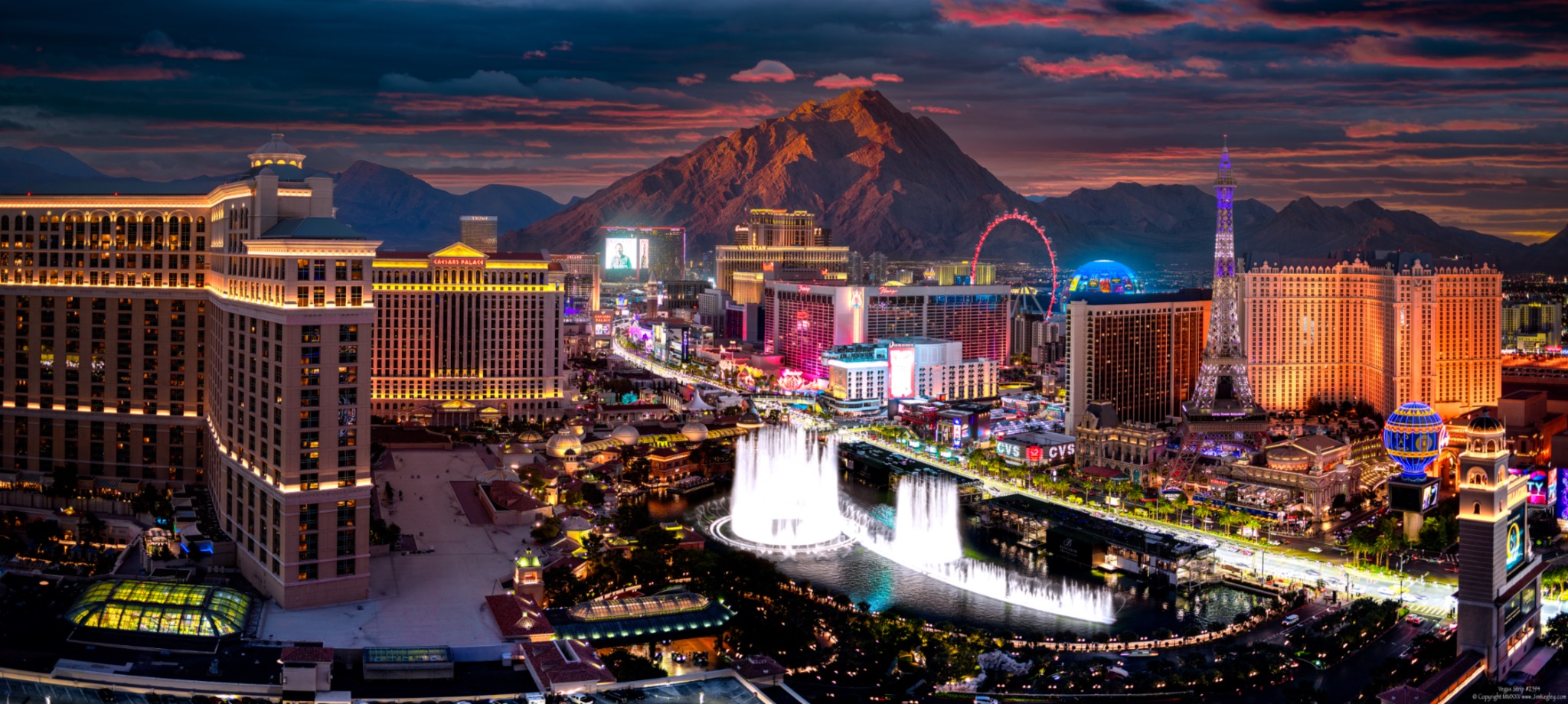 Stylized panorama of the Bellagio fountains and illuminated Las Vegas Strip beneath colorful clouds